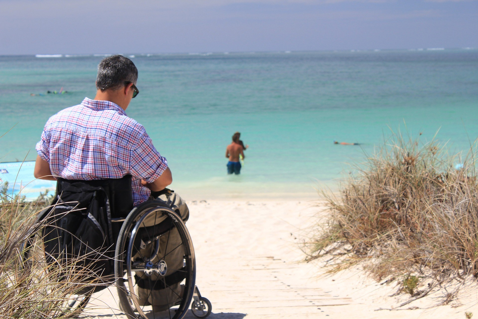 person in wheelchair at the beach