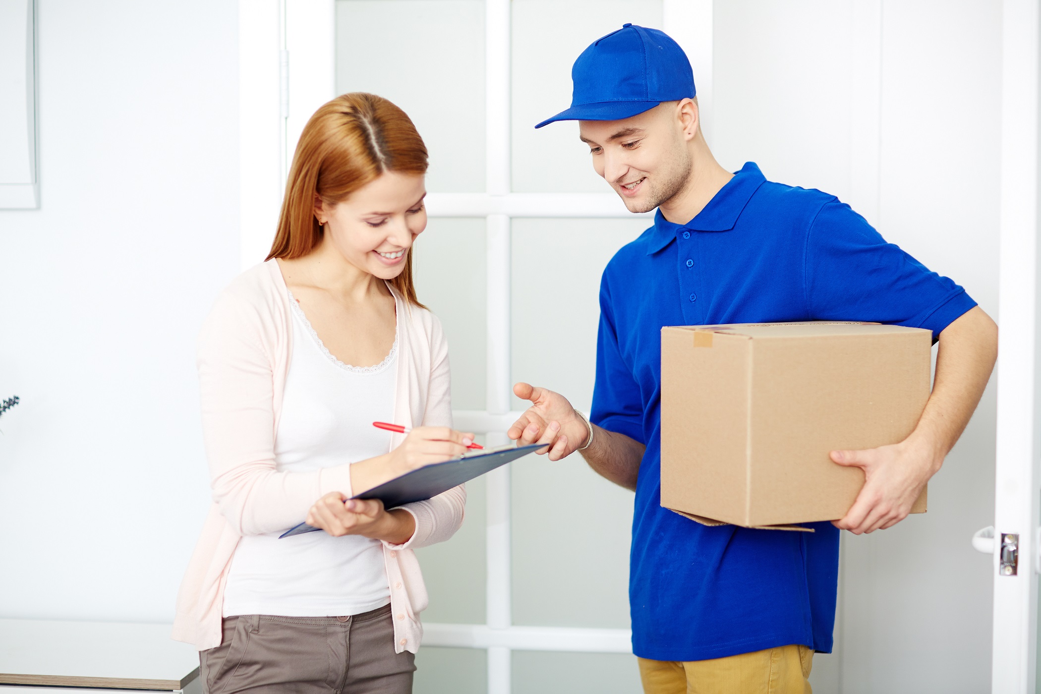 postman delivering a parcel and recipient signing  document for receipt